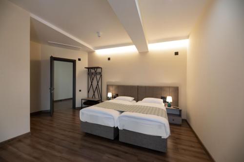 duża sypialnia z 2 łóżkami i drewnianą podłogą w obiekcie Takara Hotel & Winery w mieście Dedoplis Tskaro