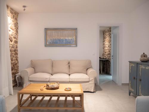 un soggiorno con divano e tavolo di Up the stairs renovated apartment with sea view a Poros