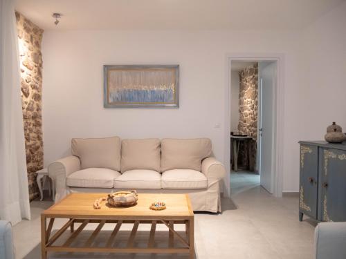 una sala de estar con un sofá y una mesa en Up the stairs renovated apartment with sea view, en Poros