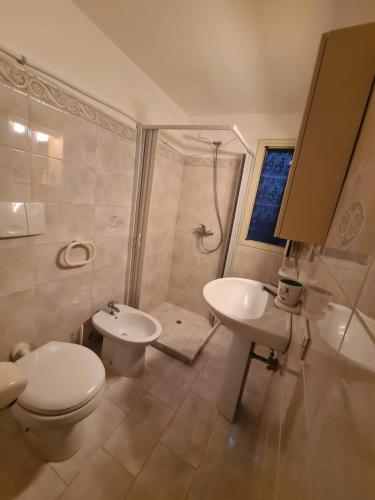 a bathroom with a toilet and a sink and a shower at casa al mare kalispera in Marina di Mancaversa
