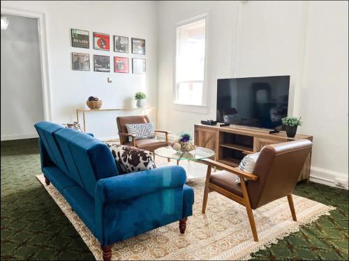 a living room with a blue couch and a tv at Bon Maison Guest House in New Orleans