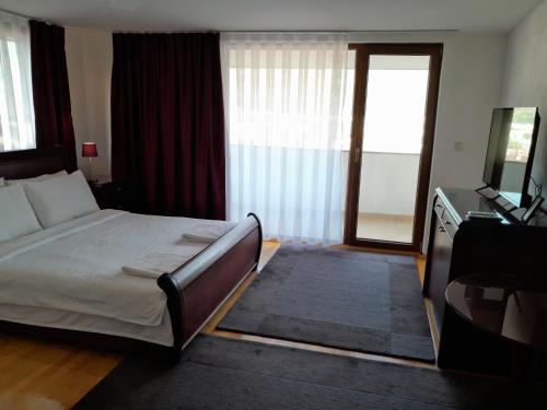 a bedroom with a bed and a television and a window at Villa Bella in Ohrid