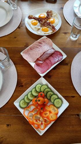 a wooden table with plates of food on it at Bubbles Breakfast and Spa in Sandefjord