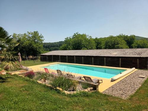 - une piscine dans une cour à côté d'un bâtiment dans l'établissement Le Séchoir des acacias, L'Orée du bois, à Saint-Léon-sur-Vézère