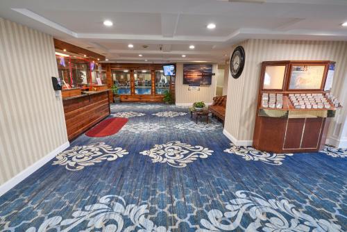 a hotel room with a lobby with blue and white carpet at Ambassador Inn and Suites in South Yarmouth