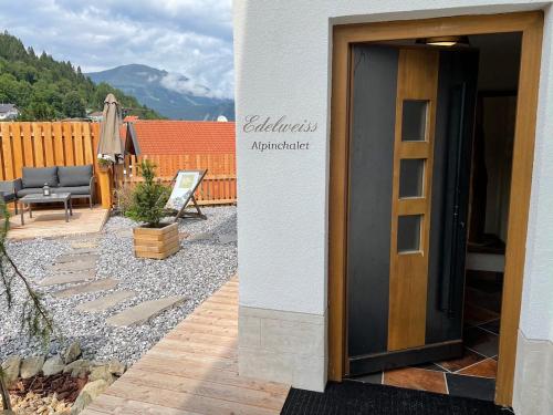 a door to a patio with a couch and a chair at Chalet EDELWEISS in Ladis