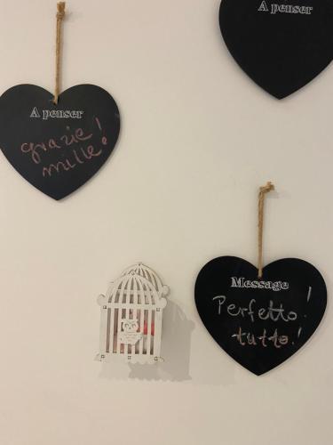 two hearts and a bird cage hanging on a wall at Bari Lory’s Home in Bari