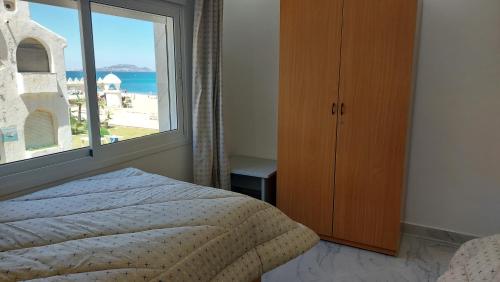 ein Schlafzimmer mit einem Bett und einem großen Fenster in der Unterkunft Al amine plage in Fnideq