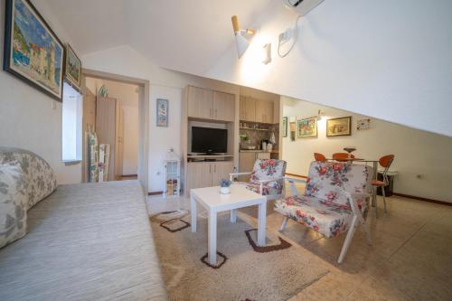 a living room with a couch and a table and chairs at Apartments Franovic in Perast