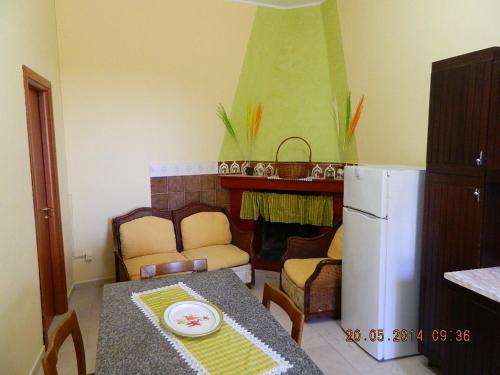 uma pequena cozinha com uma mesa e um frigorífico em Rustic cottage in Montalbano jonico em Montalbano Ionico