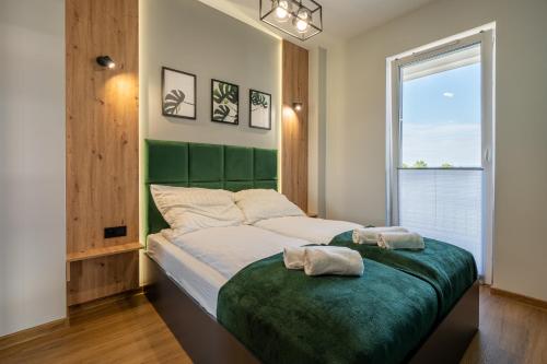 - une chambre avec un lit doté d'une tête de lit verte dans l'établissement Apartament No 34 Green - Holiday Home Zator, à Zator