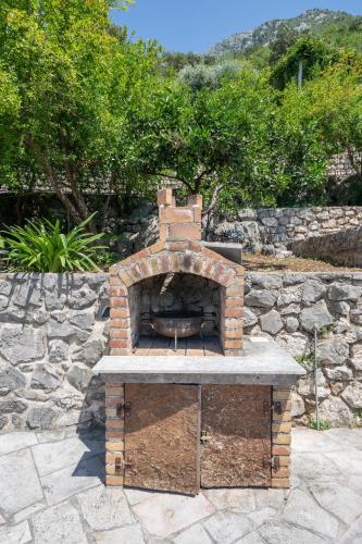 a brick oven sitting on a stone patio at Apartments Franovic in Perast