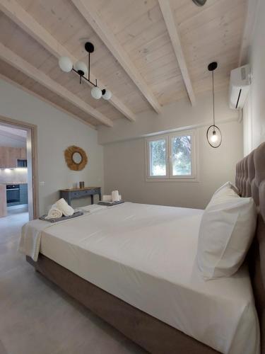 een grote witte slaapkamer met een groot wit bed bij Electra Villa & Pool Studios in Gaios