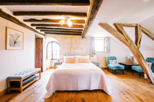 a bedroom with a large bed and wooden floors at Manoir de Jouralem in Blaison