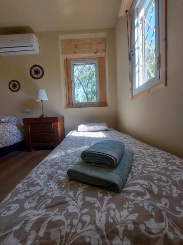 Un dormitorio con una cama con una manta. en Desert Tribe en Mitzpe Ramon