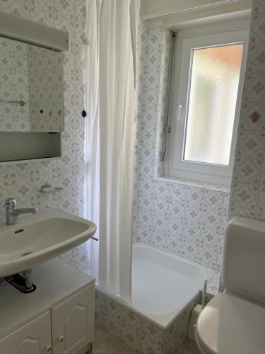 a bathroom with a sink and a toilet and a window at Residenz Majesta in Leukerbad