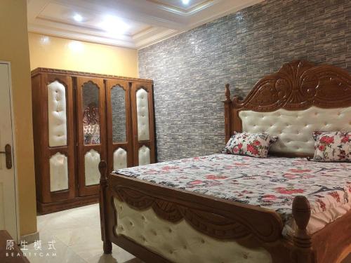 a bedroom with a bed and a brick wall at AwaMuuLamin MANNEH GUEST HOUSE in Abuko