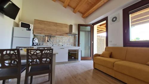 a kitchen and living room with a couch and a table at Casa vacanze Le Agavi in Modica