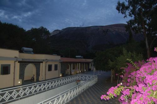 a building with pink flowers on the side of a street at Hotel Al Togo Fitness & Relax in Vulcano