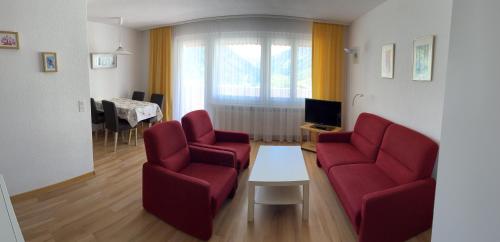 a living room with two red chairs and a table at Residenz Majesta in Leukerbad