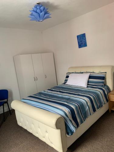 a bedroom with a bed with a blue flower on the ceiling at Starlight Self Service Accommodation in Leigh