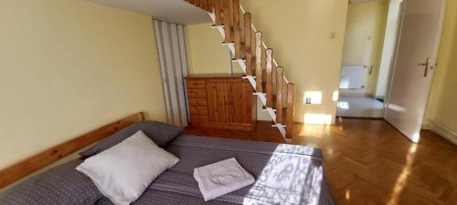 a room with a bed and a stair case at Via Tokaj Vendégház in Sátoraljaújhely