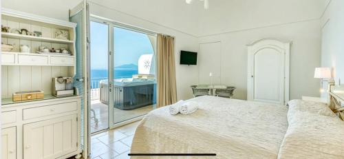 sypialnia z łóżkiem i widokiem na ocean w obiekcie Villa DAlessandro w mieście Anacapri