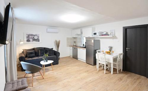 Il comprend un salon avec un canapé et une table. dans l'établissement Apartment D & Studio L, à Dobrinj