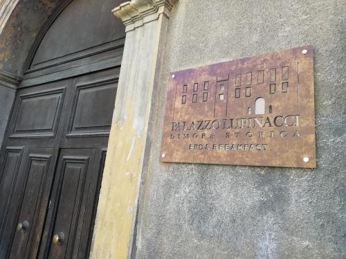 科森扎的住宿－Palazzo Lupinacci - dimora storica Bed and breakfast，门旁建筑物的一侧的标志