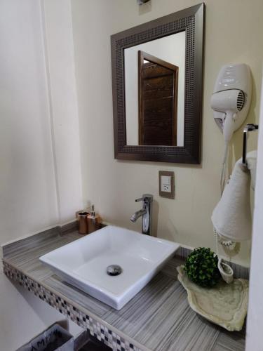 a bathroom with a white sink and a mirror at Hostería Tocali in Tlaxcala de Xicohténcatl