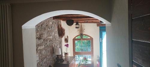 a hallway with an archway in a house with a window at Rustico La Colonna - Tremosine sul Garda in Tremosine Sul Garda