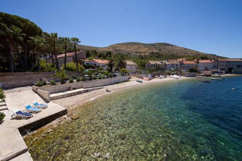 a beach with lounge chairs and the water at Nautic Studio A4 in Vis