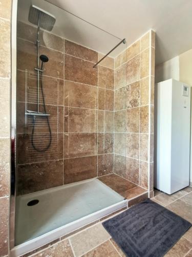 une douche avec une porte vitrée dans une salle de bain dans l'établissement Villa au lac du Salagou - 10 pers, à Octon