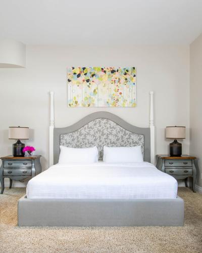 a bedroom with a large white bed with two night stands at Retro Suites Hotel in Chatham