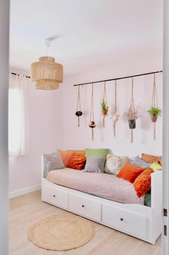 - un canapé blanc avec des oreillers colorés dans l'établissement Sacré Coeur d'Ambrussum, à Lunel