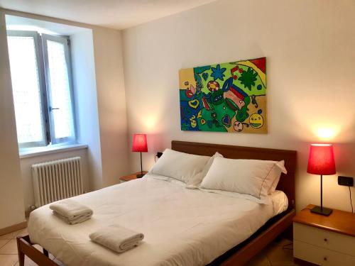 a bedroom with a bed with two lamps and a painting at Casa Rosella in Ledro