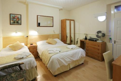 A bed or beds in a room at Saxonia Guest House 