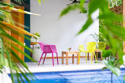 a group of chairs and a table next to a pool at La Paz del Caribe Adults Only in Puerto Viejo