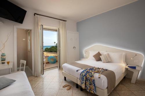 1 dormitorio con cama y vistas al océano en Hotel Casa Yvorio, en Terracina