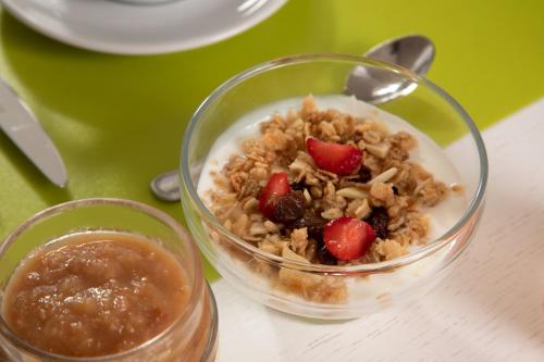 a bowl of granola and strawberries on a table at Hotel Casa Yvorio in Terracina