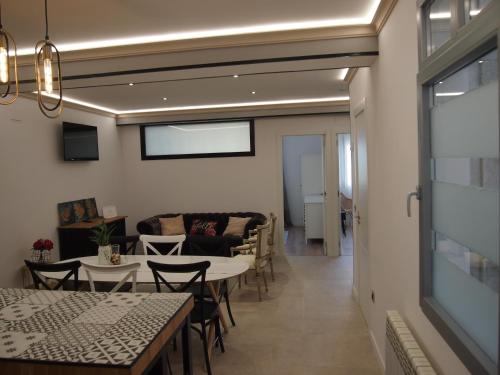 - un salon avec une table, des chaises et un canapé dans l'établissement Apartamento Isaac junto a la muralla Romana, à Lugo
