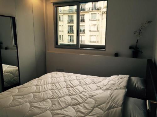une chambre avec un lit et une fenêtre dans l'établissement A deux pas des Champs Elysées, à Paris