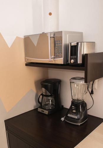 a kitchen with a blender and a microwave on a counter at Departamento Orellana 9 in Chetumal