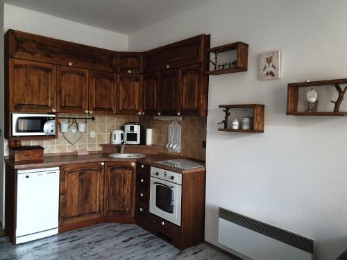 a kitchen with wooden cabinets and a white appliance at Apartmán Dávid - AD Magura in Donovaly