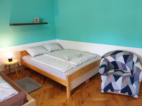 a small bedroom with a bed and a chair at Sophie Apartment in Balatonberény