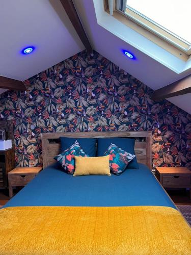 - une chambre avec un lit bleu et un mur fleuri dans l'établissement Justcozy chambre indépendante #4, à Lille