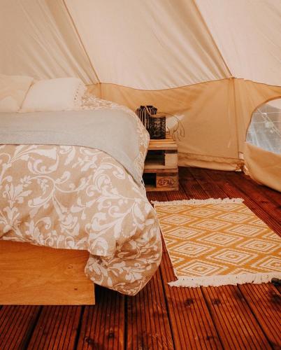 a bedroom with a tent with a bed and a rug at Rubeni in Stāķi