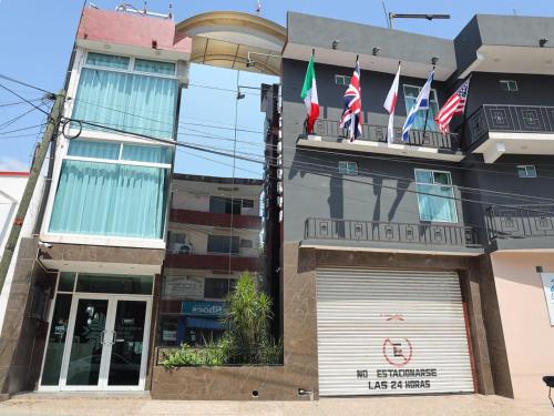 een gebouw met drie vlaggen op een balkon bij Hotel Tamtokow in Ciudad Valles