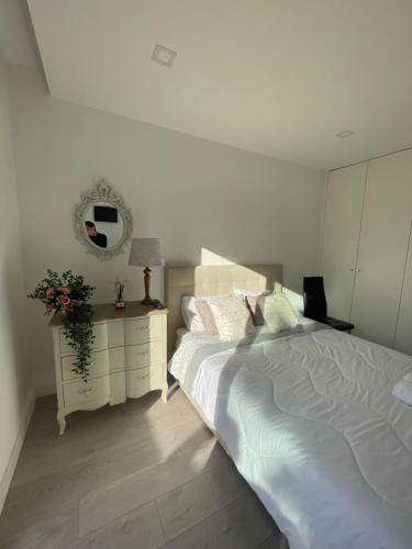 a bedroom with a bed and a dresser with a mirror at Quarto Privado em Alojamento Local perto do Rio Vez em Arcos de Valdevez in Arcos de Valdevez