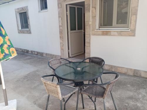 a glass table and chairs on a patio at Apartmani Bosco in Tivat